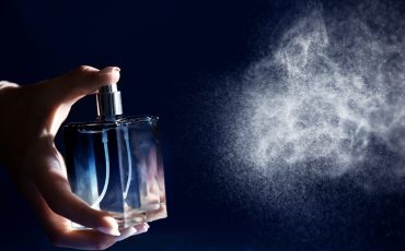 Woman,Spraying,Perfume,On,Dark,Background,,Closeup