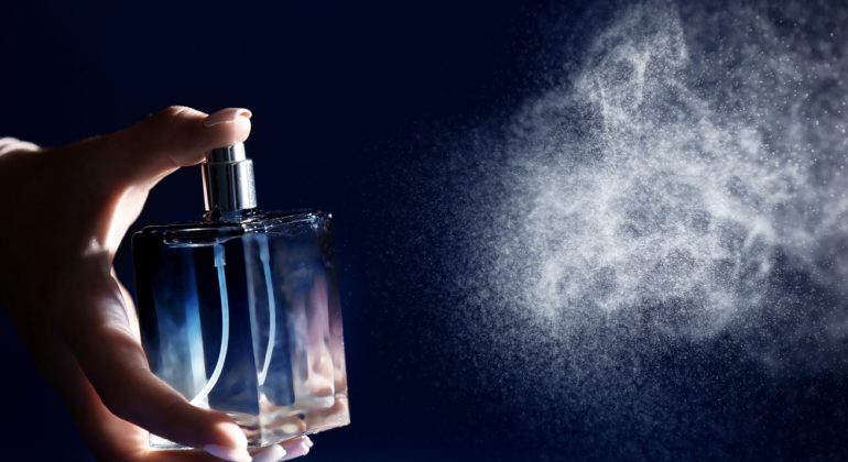 Woman,Spraying,Perfume,On,Dark,Background,,Closeup